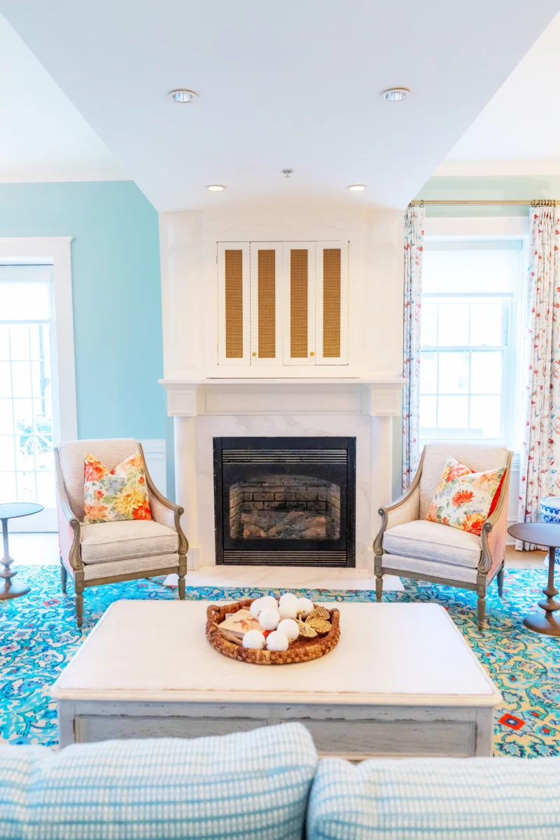 A fireplace and a blue room with showcasing chairs.