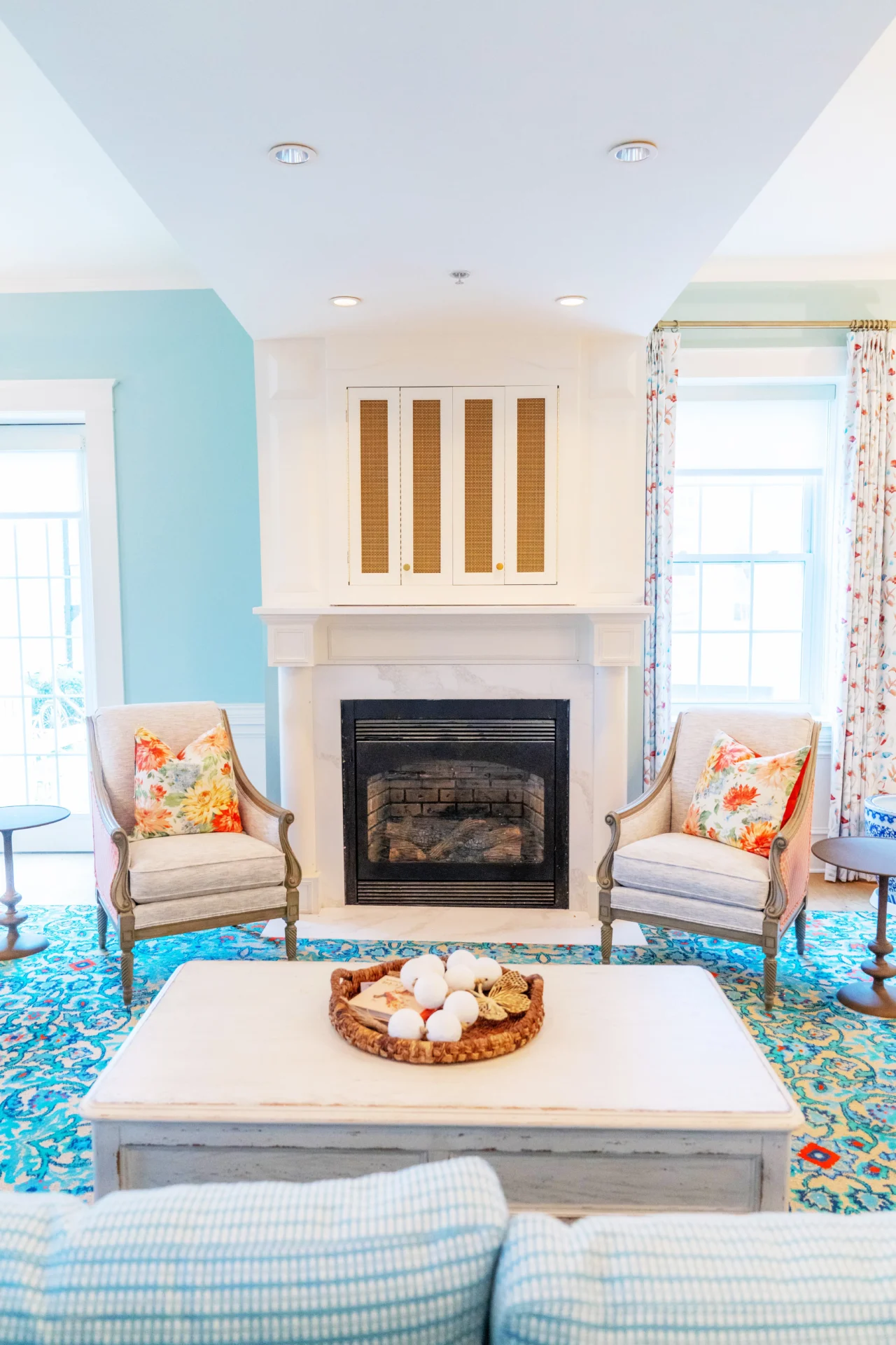 A fireplace and a blue room with showcasing chairs.