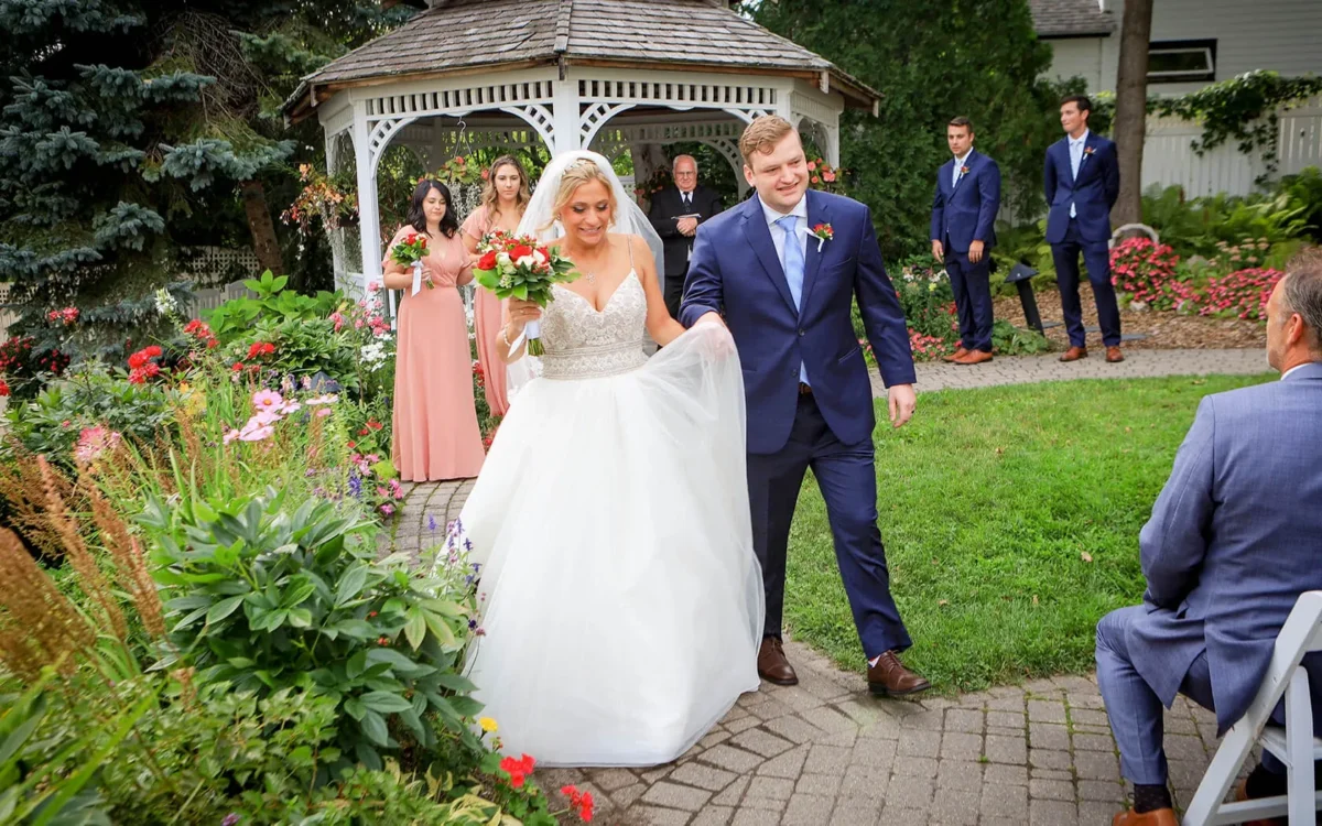 A bride and groom walking down a stone path.