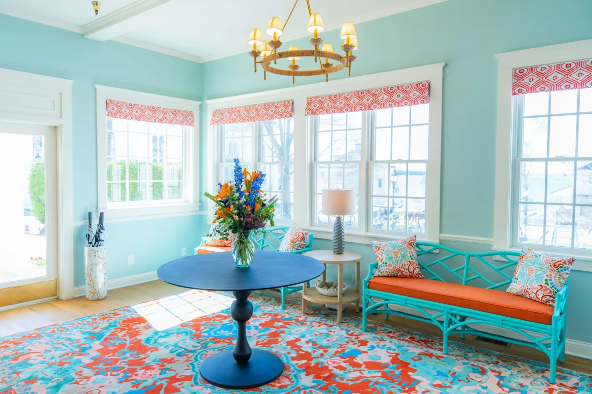 Blue room with patterned carpet with a blue table with lots of windows.