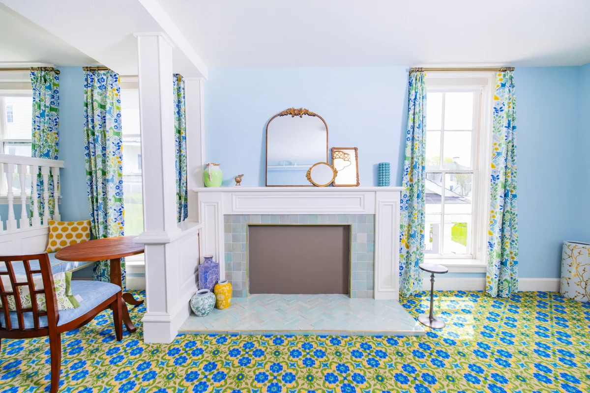 Fireplace and blue room with pattern carpet.