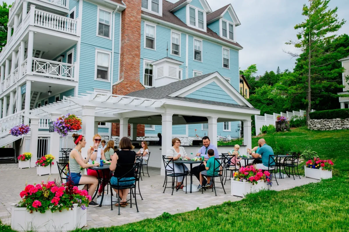 People enjoying breakfast in front of a blue hotel.
