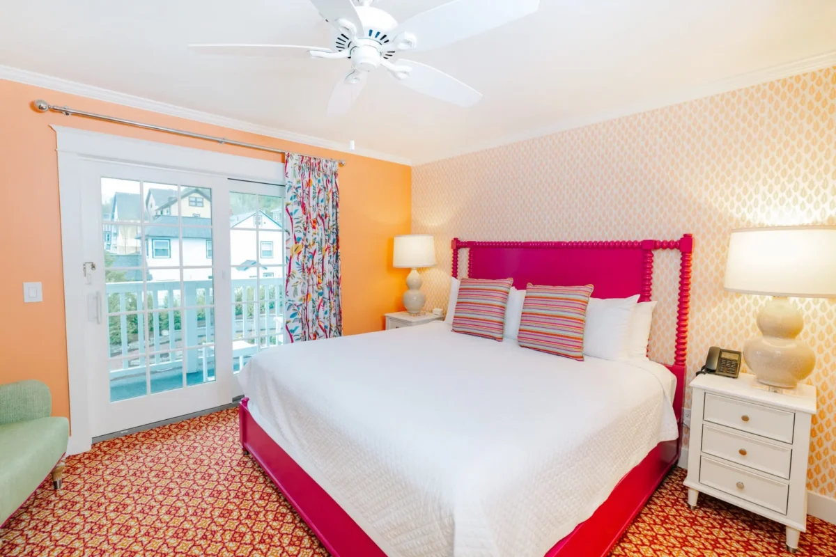 An orange room with patterned carpet and pink bed.